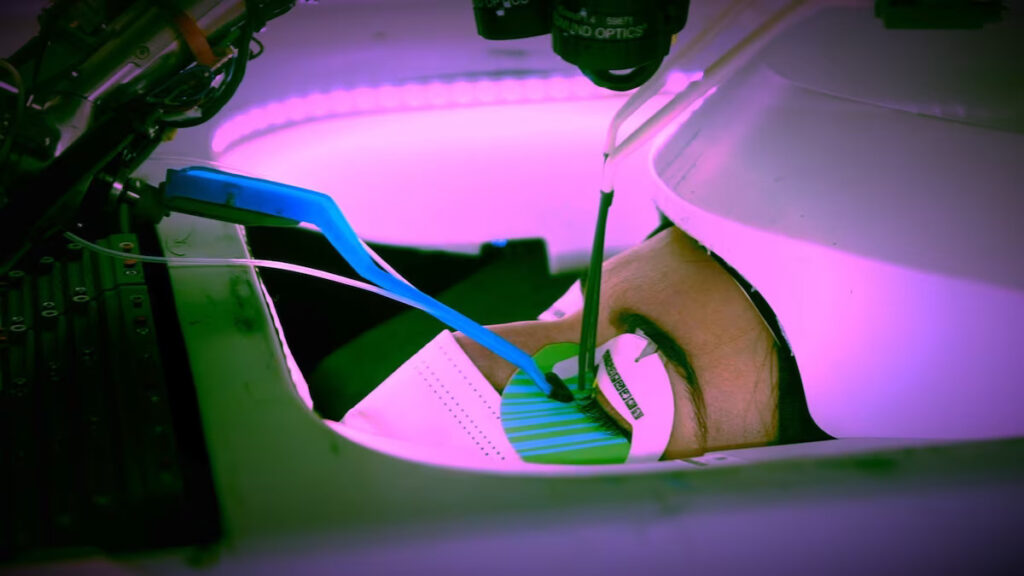 An eyelash robot is performing eyelash extension treatment on a woman.